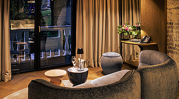 A cosy seating area with a view in the Spa Deluxe double room at Hotel Winzer