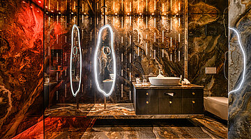 Bathroom in the Wolke 7 Luxurious bathroom in the Wolke 7 at Hotel Winzer with natural stone, an elegant vanity, illuminated mirrors and atmospheric lighting