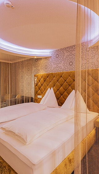 Emotion Double Room with a cosy bed at the Romantik-Wellnesshotel Winzer