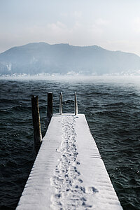 A snow-covered footbridge on Lake Attersee in winter