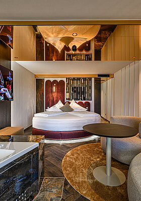 Kuscheltraum Junior Suite at Hotel Winzer with double bed, bathtub, cosy living area and contemporary interiors for two