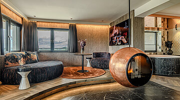 Living Area with Design Fireplace Living area in the Wolke 7 at Hotel Winzer with a cosy seating area, distinctive design fireplace and private whirlpool bath