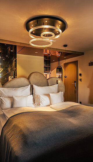 A cosy bed in a Spa Deluxe double room at the Hotel Winzer