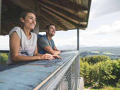 A couple are enjoying the view from a viewing tower in the Attersee-Attergau region