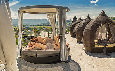 Paar liegt auf bequemen Sonnenliegen auf dem Sonnendeck im Hotel Winzer