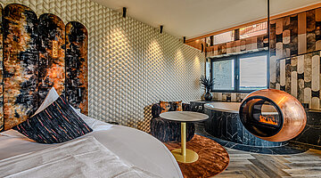 Sleeping Area in the Private Cinema Suite Sleeping area in the Private Cinema Suite at Hotel Winzer with a round double bed, design fireplace and cosy seating area