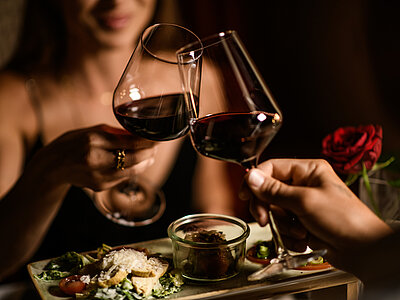A woman with a glass of wine at the food-sharing table at the Adults Only Hotel Winzer