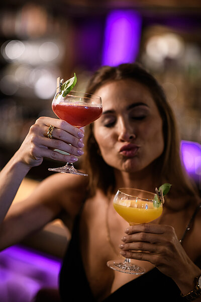 A woman with two cocktails at the Adults Only Hotel Winzer