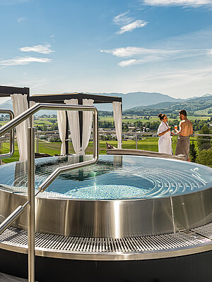 A couple are enjoying the hot tub on the sun deck at the Hotel Winzer