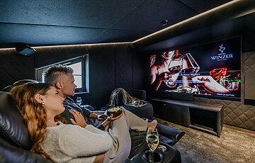 Private cinema in the Private Cinema Suite at Hotel Winzer with a large screen and comfortable cinema seats for a relaxed film night together