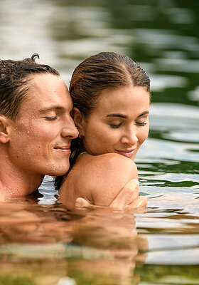 A couple in the natural pool at the Wellnesshotel Winzer