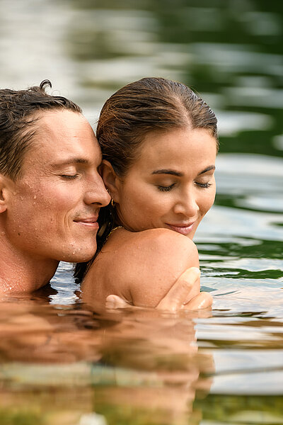 A couple in the natural pool at the Wellnesshotel Winzer