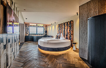 Wolke 7 at Hotel Winzer with a round double bed, private whirlpool bath and a spacious living and sleeping area for two