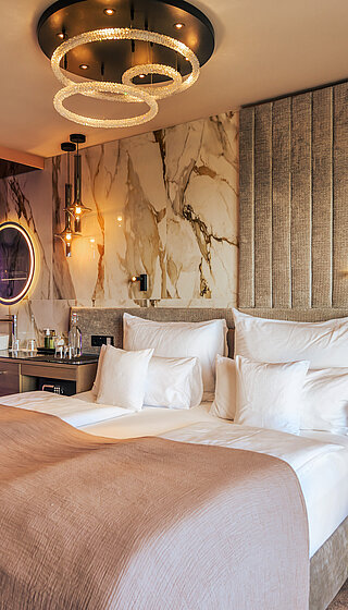 A cosy bed in the stylish Spa double room at Hotel Winzer