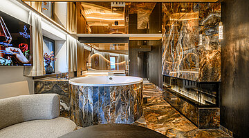 Private Spa with Whirlpool and Fireplace Private spa in the Secret Love Suite at Hotel Winzer with a whirlpool bath, contemporary fireplace and elegant natural stone finishes
