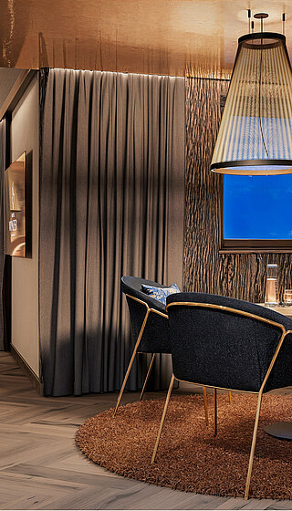 Luxuriöse Private Cinema Suite mit rundem Bett, elegantem Essbereich und kupferfarben glänzender Decke.