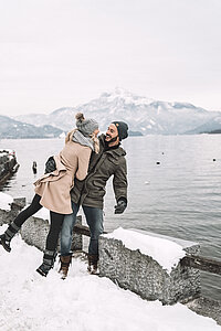 A couple on a winter walk along the lakeside promenade at Mondsee in the Salzkammergut