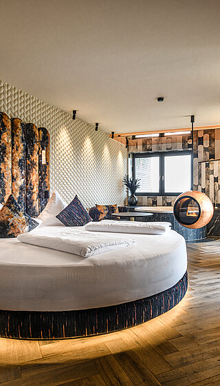 Private Cinema Suite with Round Bed and Design Fireplace Private Cinema Suite at Hotel Winzer with a round double bed, distinctive design fireplace and stylish living area for two