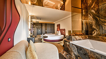 Living Area in the Kuscheltraum Deluxe Junior Suite Cosy living area in the Kuscheltraum Deluxe Junior Suite at Hotel Winzer with seating area, fireplace, balcony and countryside views