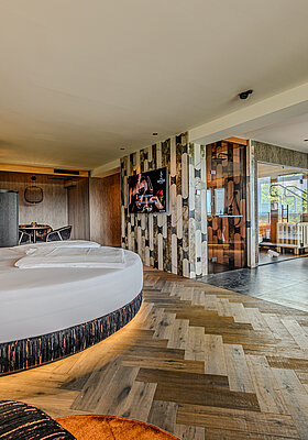 Spacious Wolke 7 at Hotel Winzer with a round double bed, private spa, design fireplace and generous space for two
