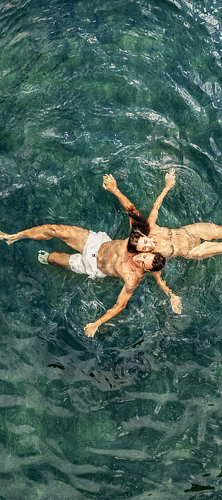 A couple in the water of the natural pool at the Winzer Wellness Hotel