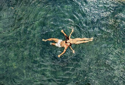 Paar im Wasser des Naturpools im Wellnesshotel Winzer